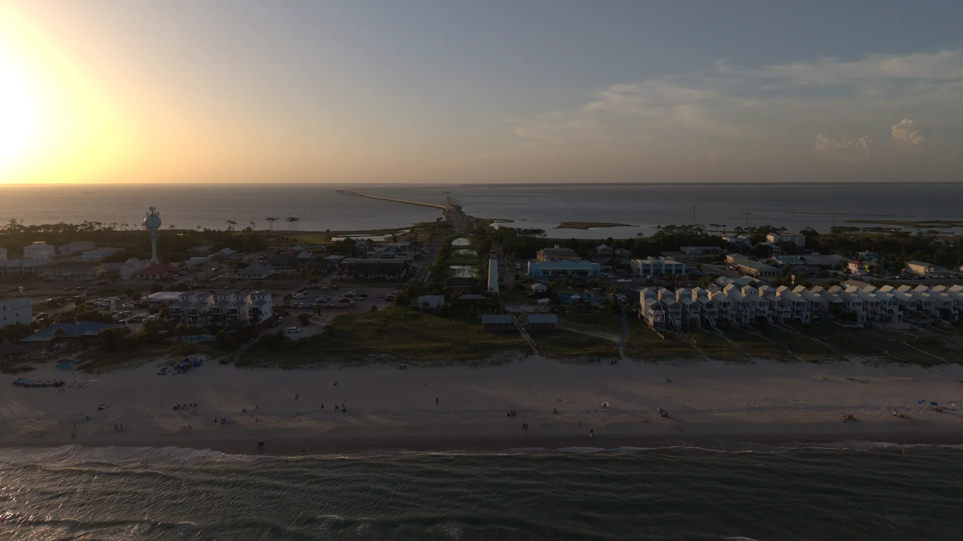 Aerial drone photo of St. George Island, Florida at sunset — the lighthouse, beach houses and the bridge to Eastpoint — by JandyLucho Marketing and Media