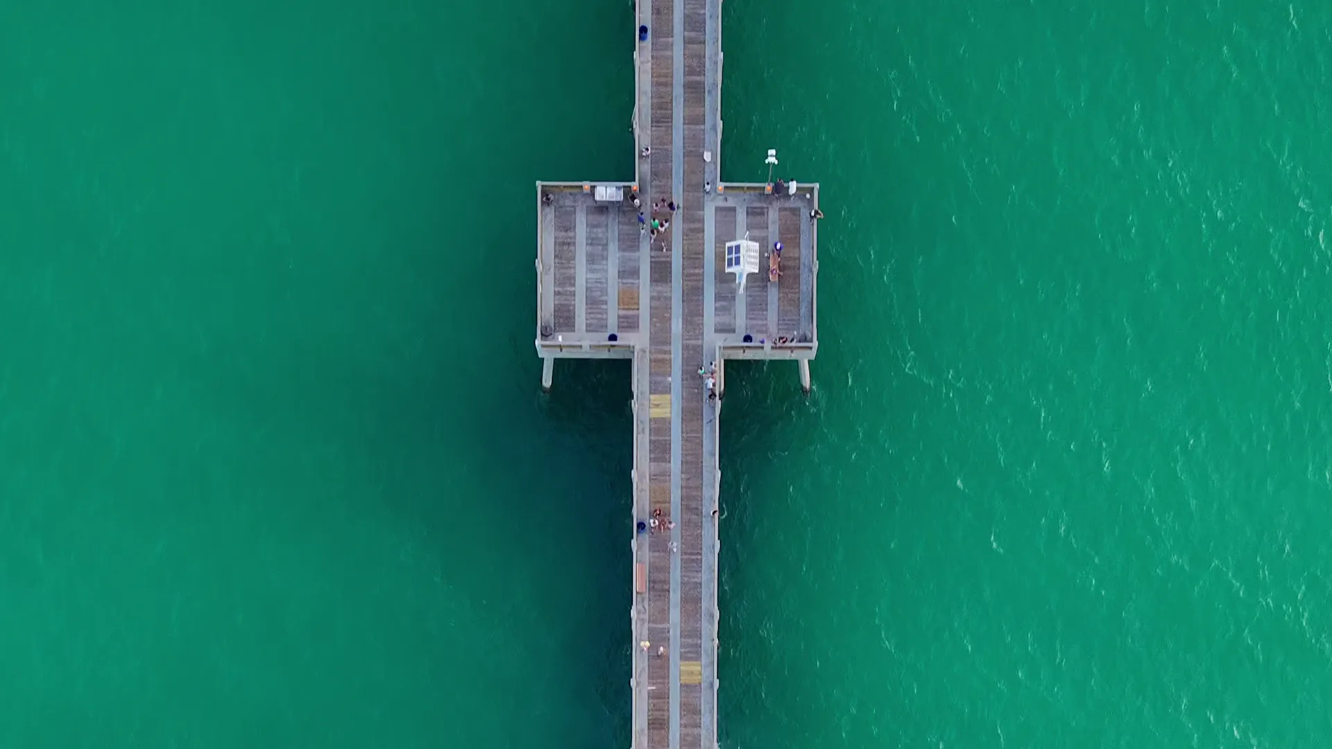 Top-down drone view of the Panama City Beach pier over emerald Gulf water by JandyLucho Marketing and Media