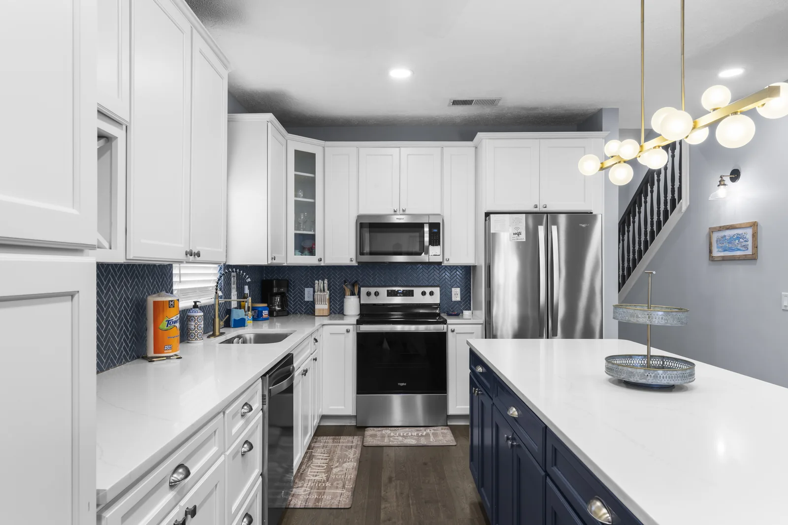 Kitchen with chandelier, stainless appliances and quartz counters