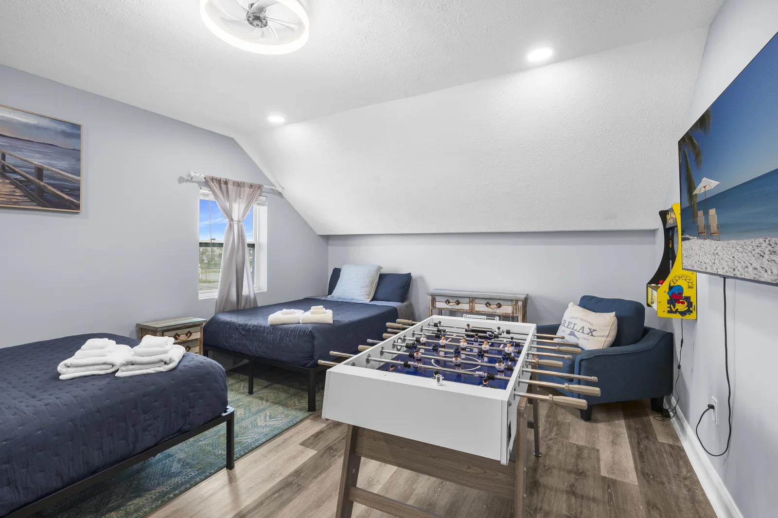 Bunk and game room with foosball table and beach mural